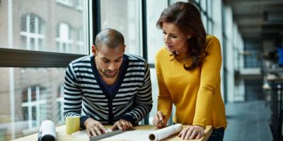 Color photo of man and woman at a drafting table in an office