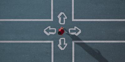 Overhead view of person at a crossroad choosing between four directions